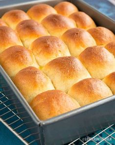 freshly baked rolls in a baking pan on a cooling rack, ready to go into the oven