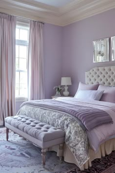 a bedroom with purple walls and white bedding in front of a large mirror on the wall