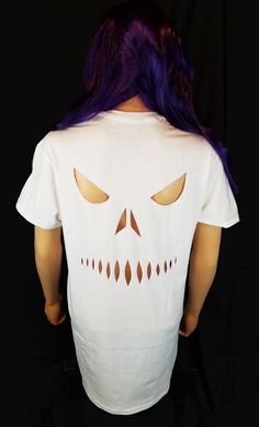 a woman with purple hair wearing a white t - shirt that has a skull on it