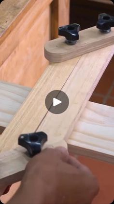 a person is working on a piece of wood with two black handles and one white handle