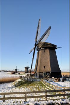 an old windmill with snow on the ground