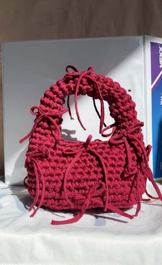 a red purse sitting on top of a table next to an open laptop computer case