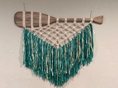 a wall hanging made out of yarn and wood