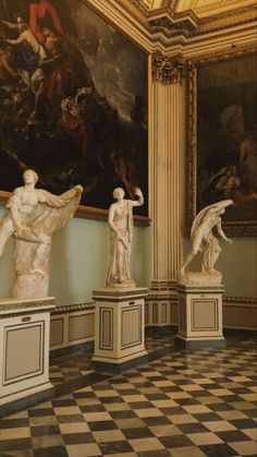 marble statues in an ornate room with paintings on the walls and flooring, along with black and white checkered tile