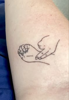 two hands holding each other on the left side of the arm, with one hand in the middle