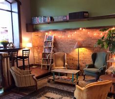 a living room filled with furniture and a fire place next to a wall covered in books