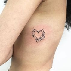 a woman's chest with a tattoo on it that has a heart in the middle