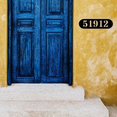 a blue door with the number 5192 on it in front of a yellow building