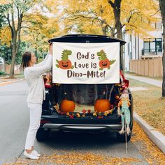 a woman holding up a sign that says god's love is dino - mitt