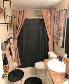 a bathroom with a black shower curtain and rugs on the floor in front of it