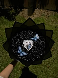 a person holding a paper plate with two blue butterflies on it and a heart in the center