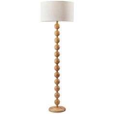 a tall wooden floor lamp with a white shade on the top and bottom part of it