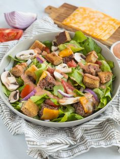 a salad in a bowl with dressing and cheese on the side, ready to be eaten