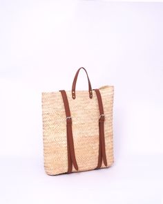 Do you want to look stylish and hippy? Get your hands on this handmade straw bag. It's high quality, eco-friendly, and handcrafted by women in Morocco. Its design is unique and timeless. Get yours now! we are proud to introduce our signature straw french bag to you. it is handmade by our talented artisan who has been working with us for years. this beautiful bag has a unique design that you would find nowhere else. the light and durable material are ideal for taking the bag on your adventures. Style is an important part of your life. The straw bag is a great way to spice up your look. You can either choose from our pre-made designs or customize the bag to your liking. Item's details: *Handmade in Morocco *Material: 100% Woven natural palm straw *Trim: 100% Vegan Leather Dimensions : Height Brown Straw Backpack Bag For Travel, Brown Straw Backpack For Travel, Beige Straw Backpack For Travel, Artisan Summer Bags With Adjustable Strap, Artisan Bags With Adjustable Strap For Summer, Straw Backpack With Braided Handles For Travel, Natural Straw Backpack For Travel, Artisan Summer Travel Bag, Casual Straw Backpack Bag For Everyday Use