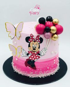 a minnie mouse cake is decorated with balloons