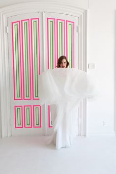 a woman standing in front of a pink door