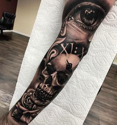 a man's arm with a skull and eye tattoo on it