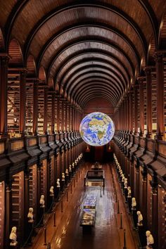 the inside of a library with many bookshelves and a globe on the wall