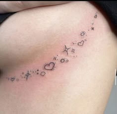 a woman's stomach with stars and hearts tattoo on her left side ribcage