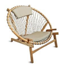 a chair made out of wood and rope with a cushion on the back, sitting in front of a white background