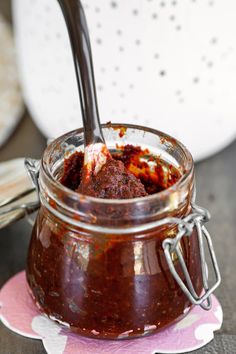 a spoon in a jar filled with sauce