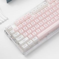 a pink and white keyboard sitting on top of a desk