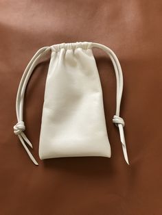 "This leather eyeglass pouch bag is made with a beautiful cream colored Italian Nappa leather. It is so soft and supple. Drawstring closure All of the leather I work with is hand selected by me ensuring you are getting the very best. handcrafted by me Shirlbcreationstoo here in the USA Color -Creme Pouch Size approx overall 6\"H x 3 1/2\"W" White Pouch For Everyday Use, Classic Cream Bag For Gift, Classic Cream Bags For Gifts, Everyday Beige Leather Pouch, Classic Cream Bag Perfect For Gifts, White Leather Pouch With Removable Pouch, Cream Mobile Phone Bag As Gift, White Mobile Phone Pouch For Everyday, Everyday White Mobile Phone Pouch