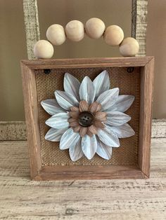 a wooden frame with a flower and some balls on top