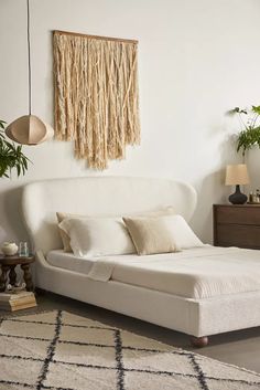 a white bed sitting in a bedroom on top of a rug