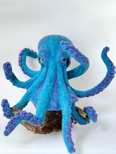 an octopus stuffed animal sitting on top of a piece of wood