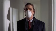 a man in a suit and tie wearing a mask