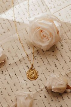 a rose and some letters on top of paper with writing in it, including a wax stamp