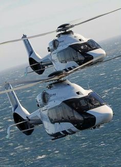 two white and black helicopter flying over the ocean with caption in spanish above it