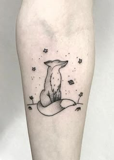 a black and white tattoo of a fox sitting on top of a hill with stars