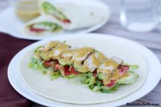 two plates with tacos on them sitting on a table next to glasses and water