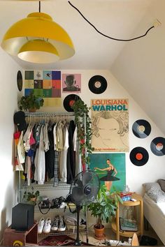 a room filled with lots of different types of clothes and records hanging on the wall