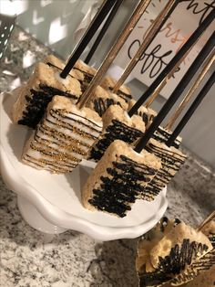 desserts are arranged on a white plate with black and gold decorations