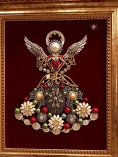 an ornate christmas ornament is displayed in a gold frame on a red wall