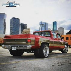 a red pick up truck parked in front of tall buildings