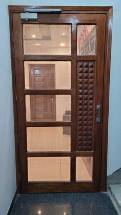 an open wooden door with glass panels on the outside