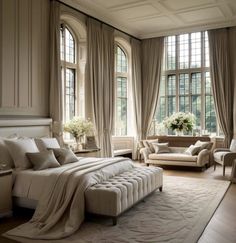 an elegant bedroom with white furniture and large windows