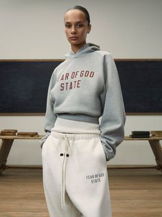 The Womens Essentials Fleece Hoodie is made in a heavy 480gsm core fleece to provide additional body and structure to its round, cropped silhouette. Collegiate-inspired "Fear of God State" is screen printed on the front. Details include an overlapped neckline hoodie, rib-knit cuffs, and waist-hem. The Essentials Fear o Womens Essentials, School Collection, Brand Magazine, Fear Of God Essentials, Fear Of God, Women Essentials, Womens Fleece, Kids Tops, Cropped Hoodie