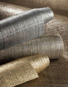 three rolls of metallic fabric on top of each other in different sizes and colors, with one rolled to the side