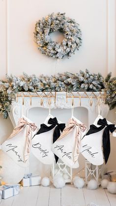 three stockings hanging from a rack in front of a fireplace with christmas decorations on it