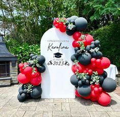 the balloon arch is decorated with red and black balloons