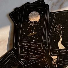 five of wands tarot cards sitting on top of a marble table with the moon in the background