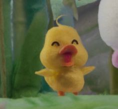 a small yellow toy duck standing next to a stuffed animal bunny in front of plants