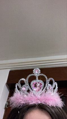 a woman wearing a tiara with pink feathers