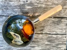 a pan filled with food sitting on top of a wooden table next to a spatula