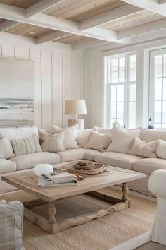 a living room filled with white furniture and pillows